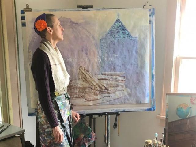 Julie Green, artist, standing in front of her easel